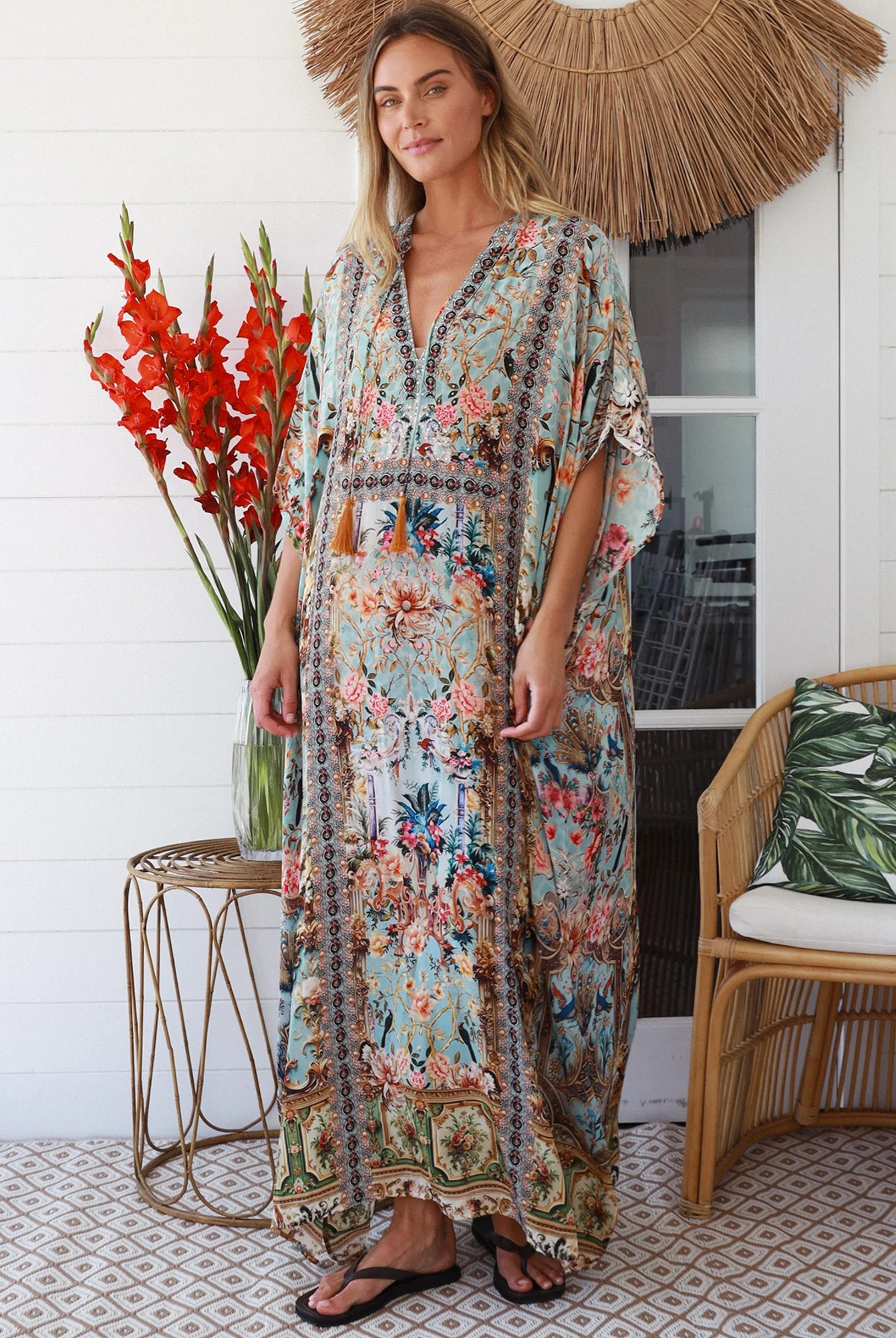 Woman wearing turquoise floral resort luxe kaftan with tassel ties - boho resortwear Australia