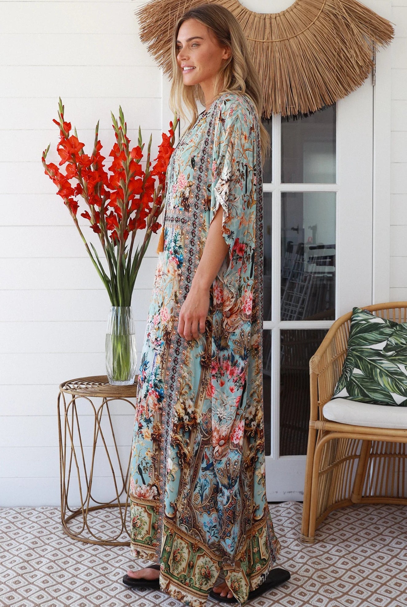Woman wearing turquoise floral resort luxe kaftan with tassel ties - boho resortwear Australia