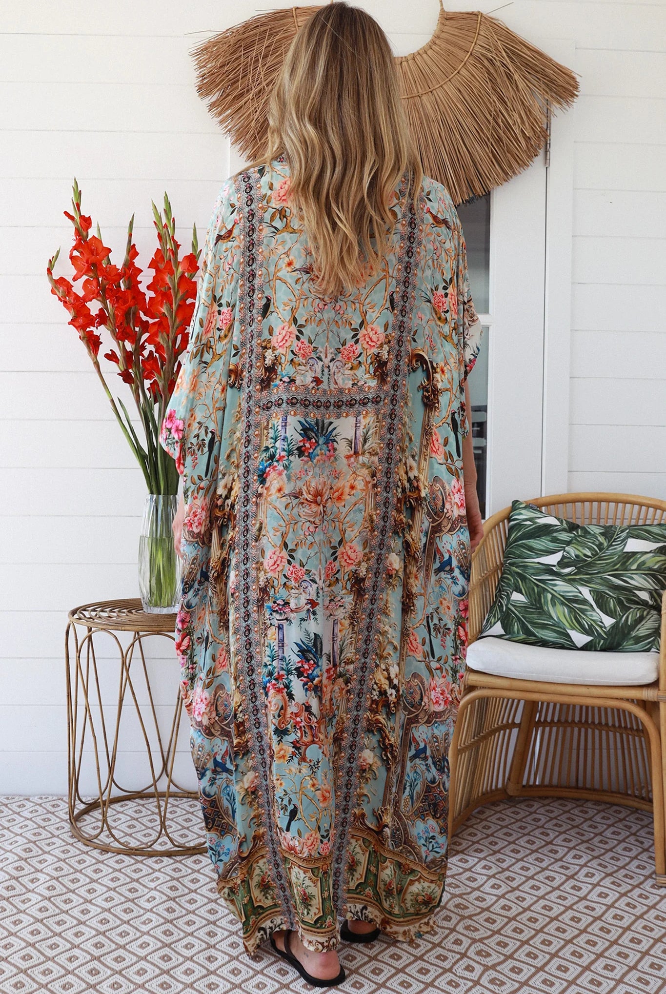 Woman wearing turquoise floral resort luxe kaftan with tassel ties - boho resortwear Australia