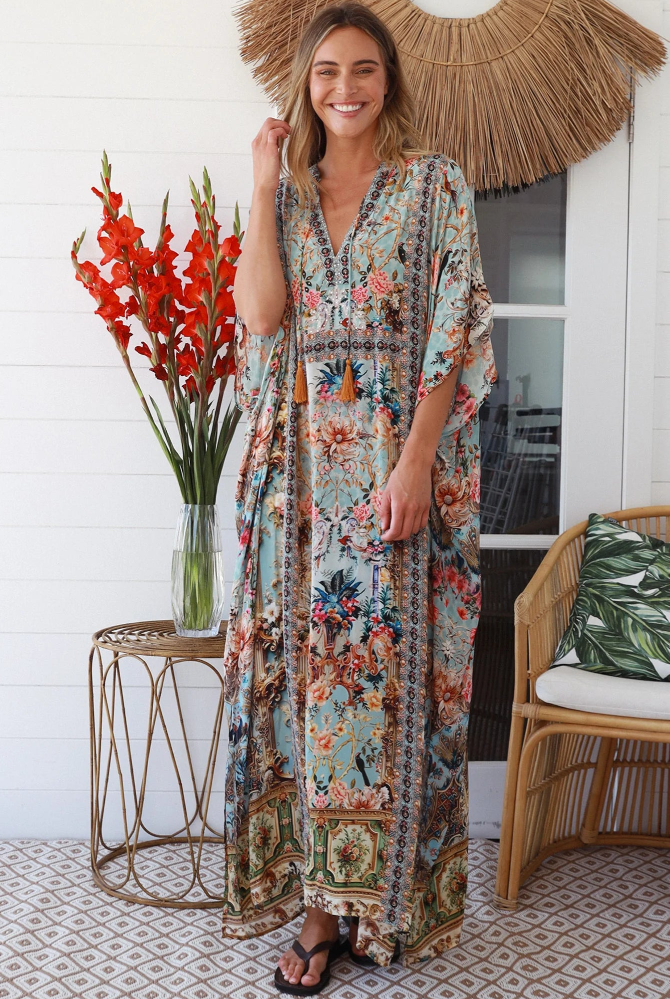 Woman wearing turquoise floral resort luxe kaftan with tassel ties - boho resortwear Australia