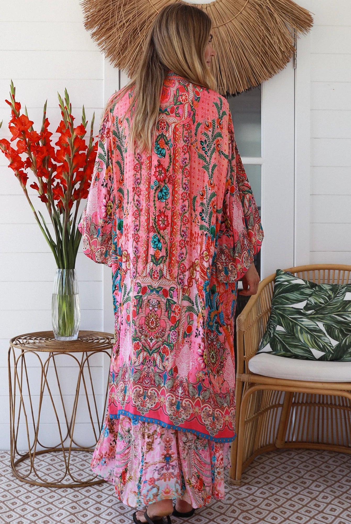 Woman in rose floral viscose-crepe kimono with turquoise accents and side splits - Peacock Feather Resort Luxe