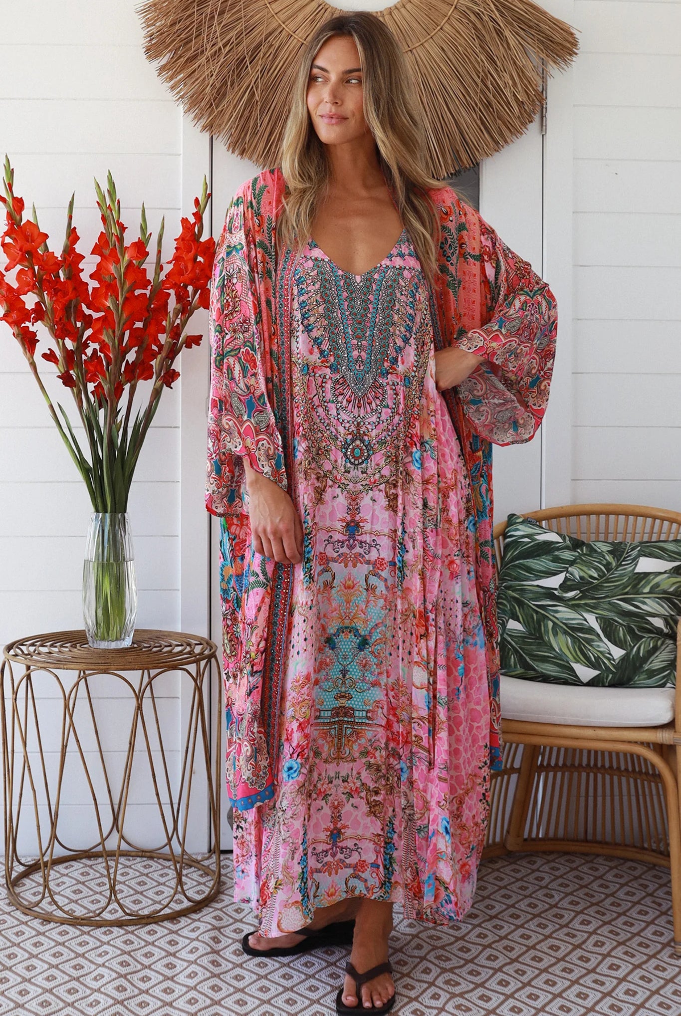 Woman in rose floral viscose-crepe kimono with turquoise accents and side splits - Peacock Feather Resort Luxe