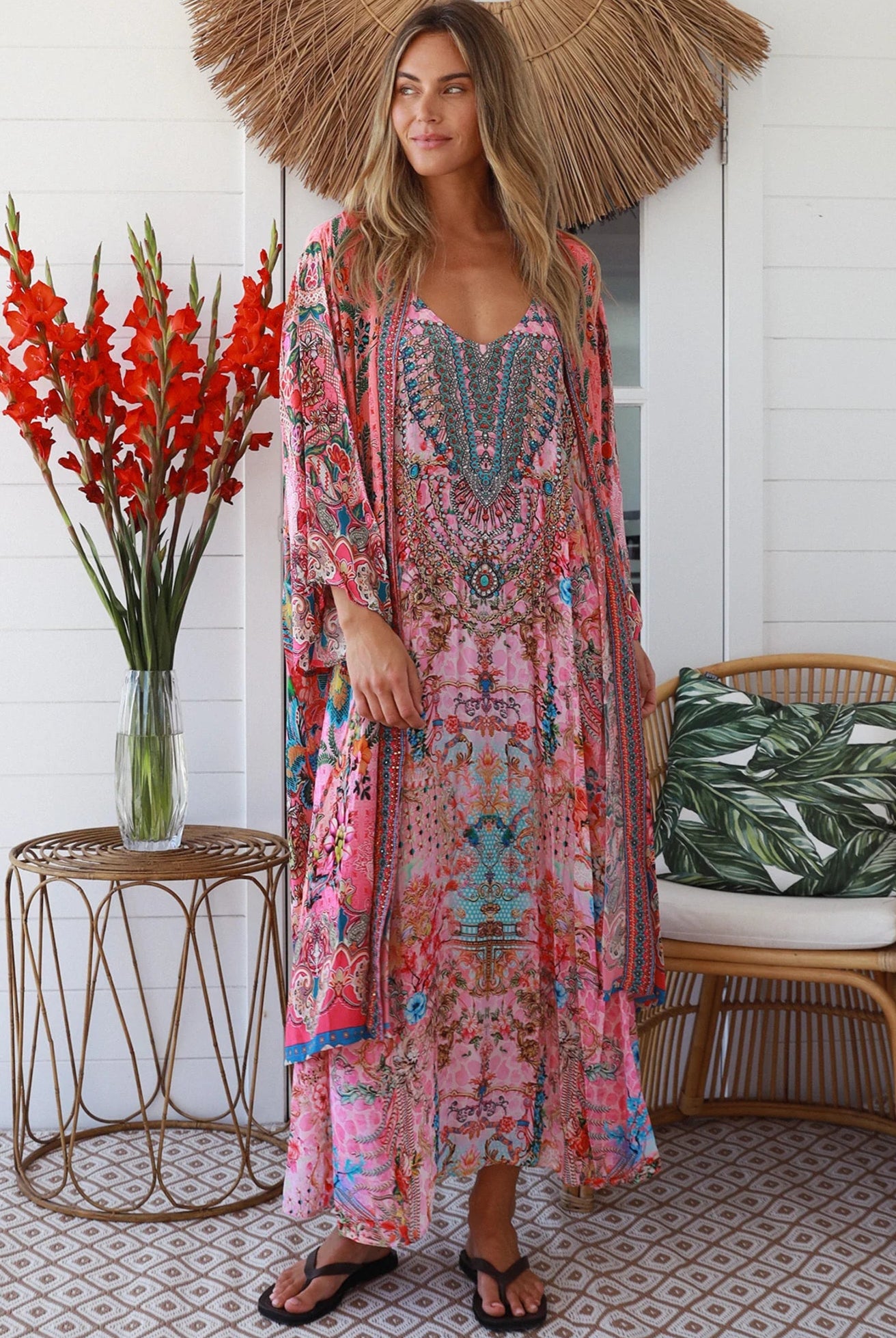 Woman in rose floral viscose-crepe kimono with turquoise accents and side splits - Peacock Feather Resort Luxe
