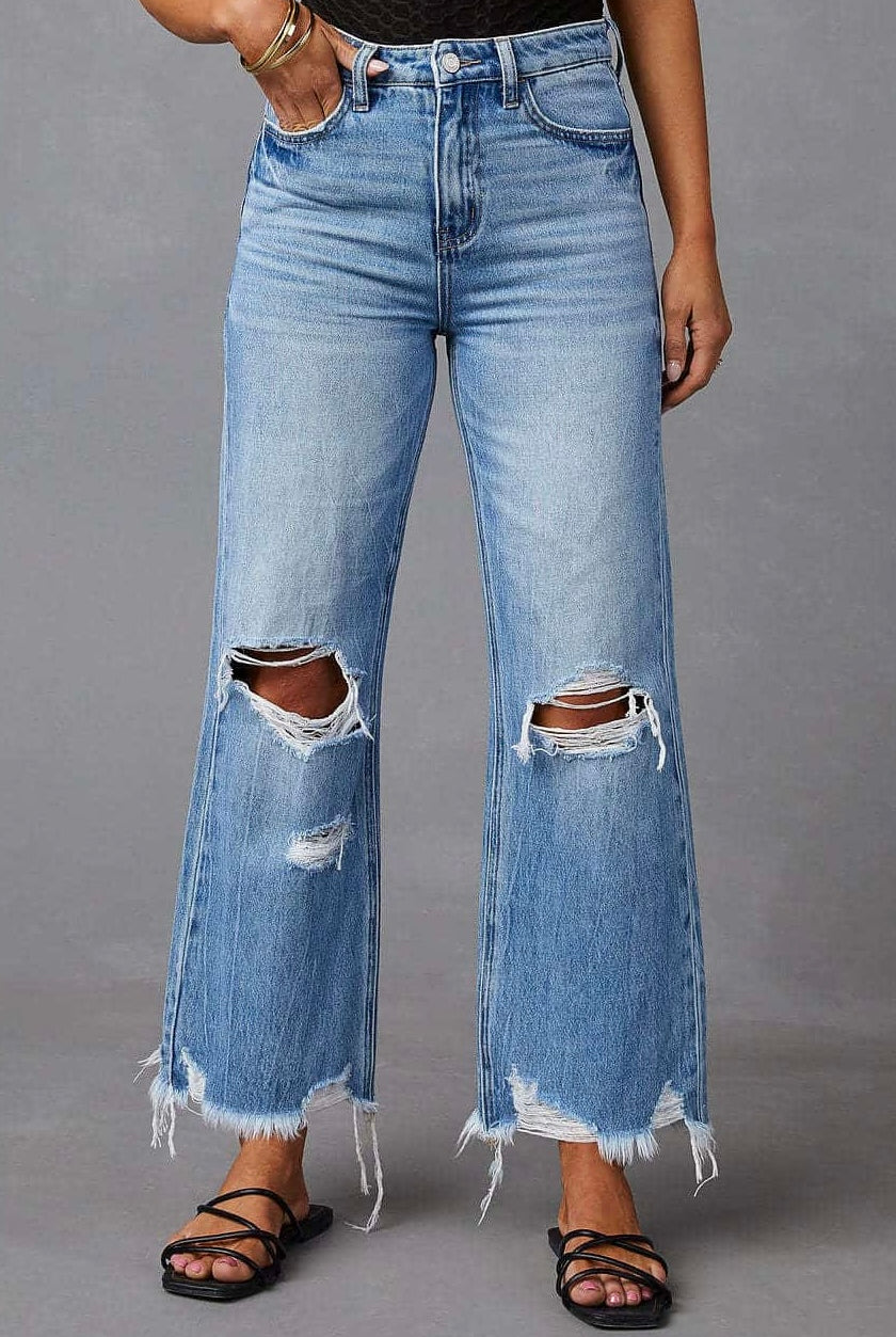 Woman wearing high-waisted light blue wide-leg jeans with raw hem and black tank - boho denim jeans Australia.