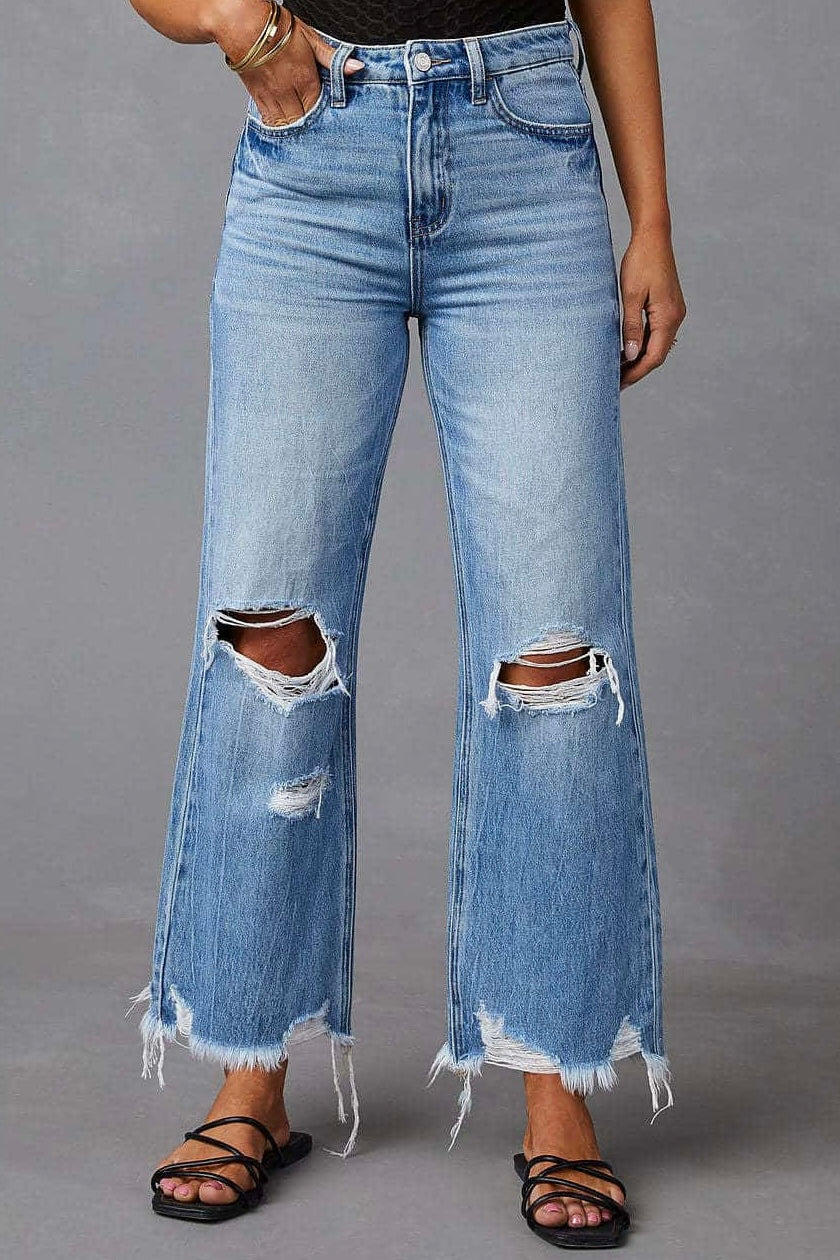 Woman wearing high-waisted light blue wide-leg jeans with raw hem and black tank - boho denim jeans Australia.