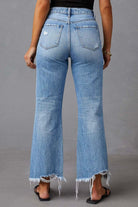 Woman wearing high-waisted light blue wide-leg jeans with raw hem and black tank - boho denim jeans Australia.