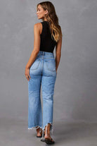 Woman wearing high-waisted light blue wide-leg jeans with raw hem and black tank - boho denim jeans Australia.