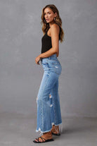Woman wearing high-waisted light blue wide-leg jeans with raw hem and black tank - boho denim jeans Australia.