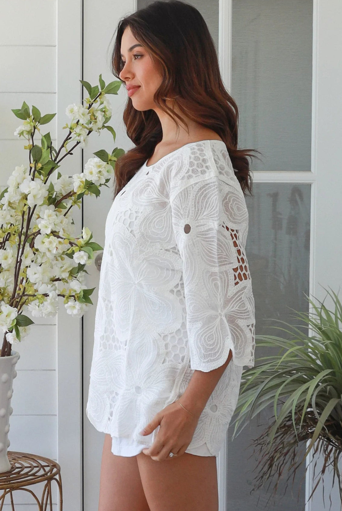 White embroidered cotton top with scalloped hem and three quarter sleeves styled for summer