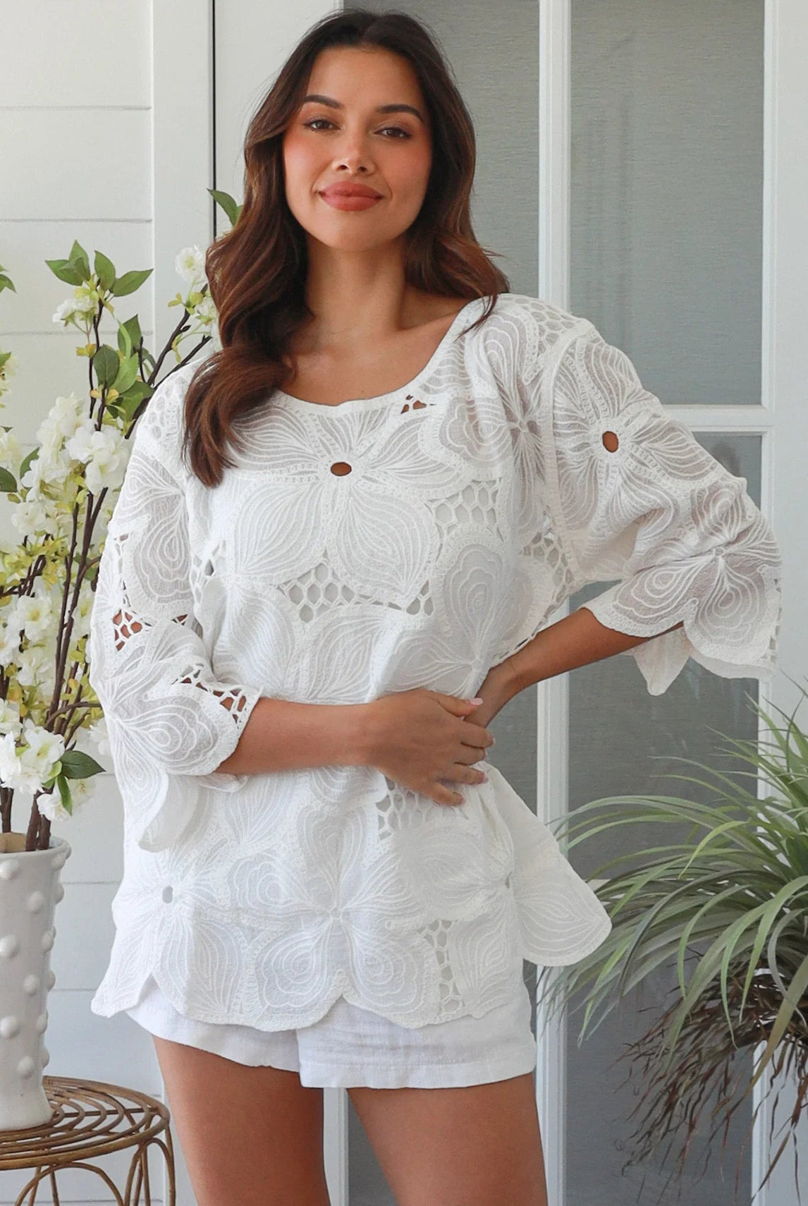White embroidered cotton top with scalloped hem and three quarter sleeves styled for summer