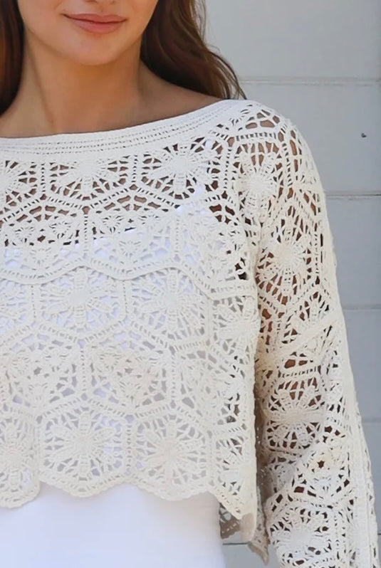 Cream crochet cotton long sleeve crop top with scalloped hem and flared cuffs styled with white shorts