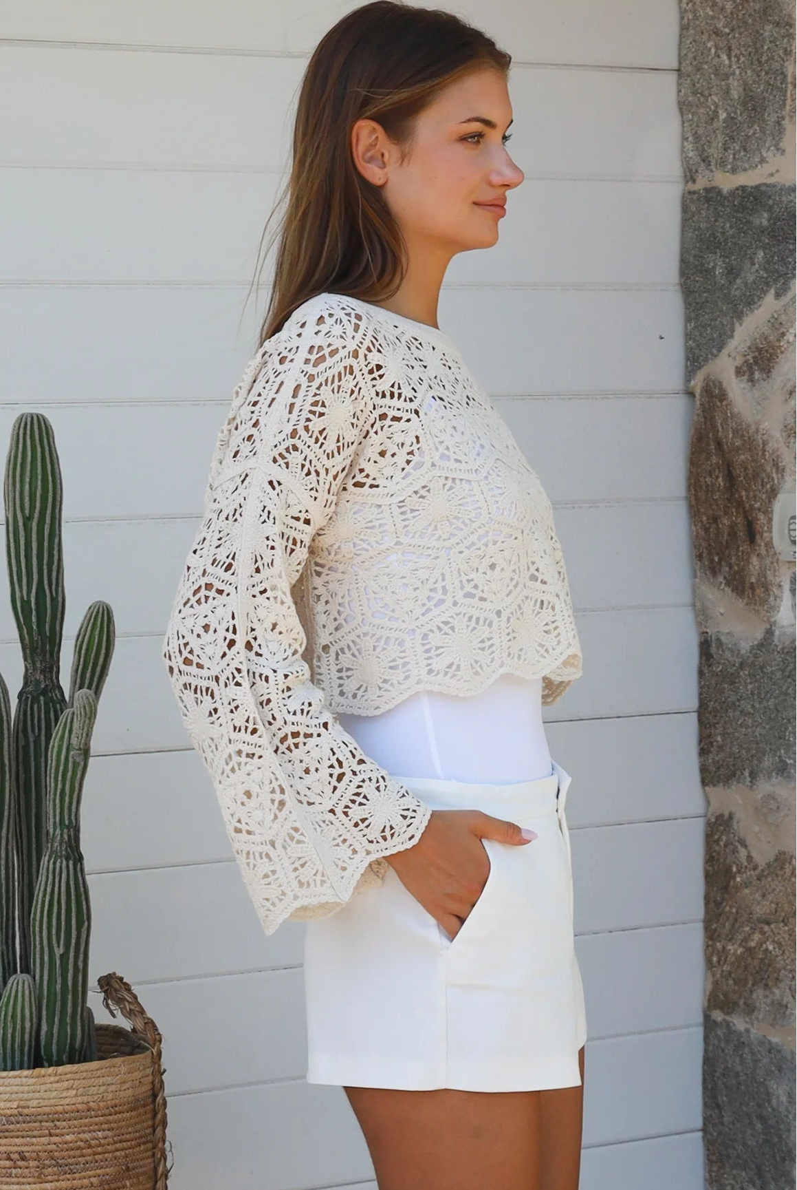 Cream crochet cotton long sleeve crop top with scalloped hem and flared cuffs styled with white shorts