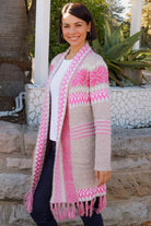 Woman wearing longline rose pink and cream boho knit cardigan with fringe hem - Australian winter fashion.