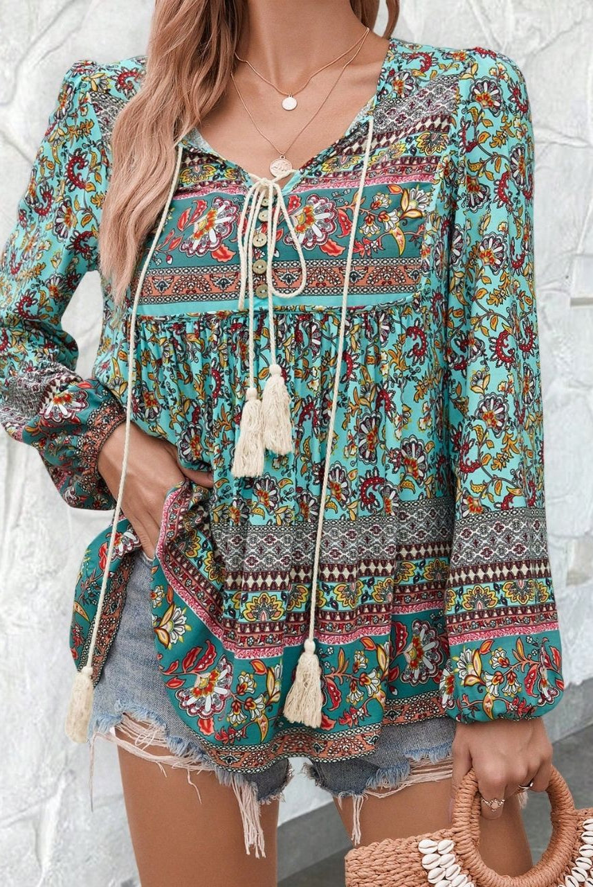 Woman in a vintage turquoise floral boho blouse with long peasant sleeves and tassel ties - The Jasmine Road Top Australia.