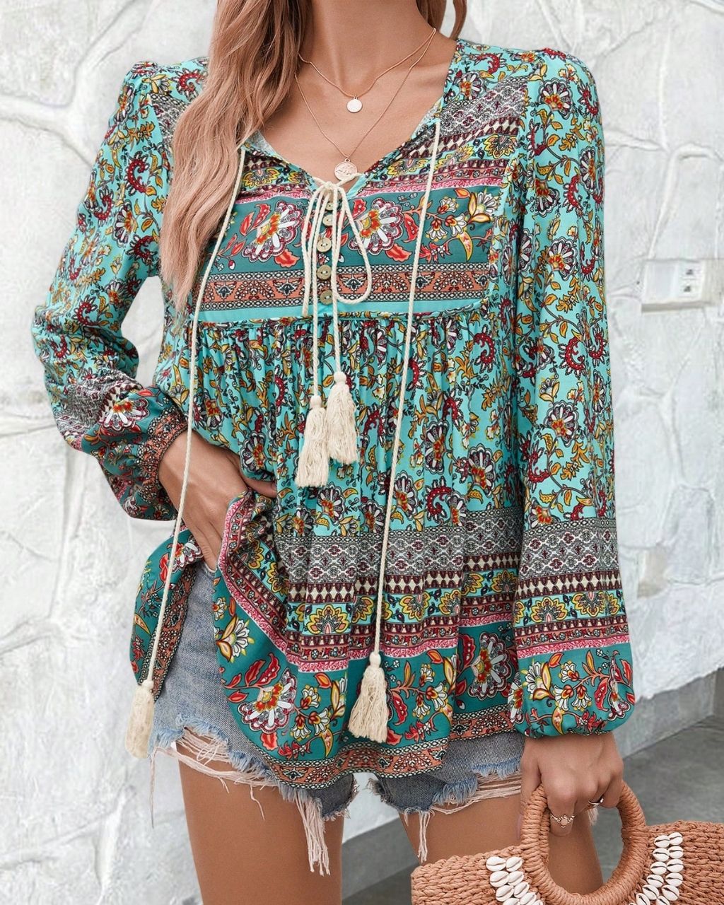 Woman in a vintage turquoise floral boho blouse with long peasant sleeves and tassel ties - The Jasmine Road Top Australia.