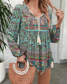 Woman in a vintage turquoise floral boho blouse with long peasant sleeves and tassel ties - The Jasmine Road Top Australia.