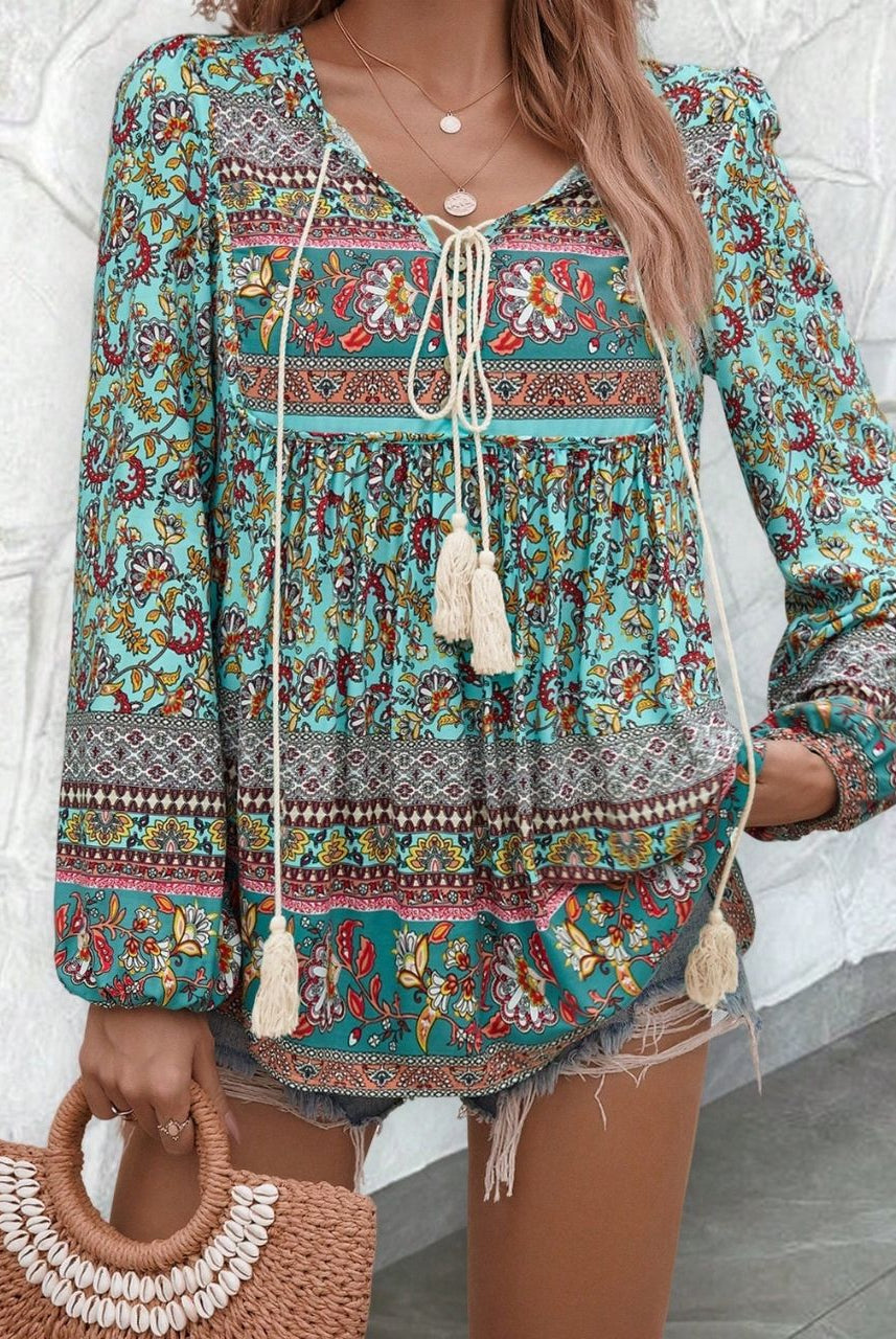 Woman in a vintage turquoise floral boho blouse with long peasant sleeves and tassel ties - The Jasmine Road Top Australia.