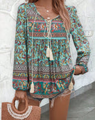 Woman in a vintage turquoise floral boho blouse with long peasant sleeves and tassel ties - The Jasmine Road Top Australia.