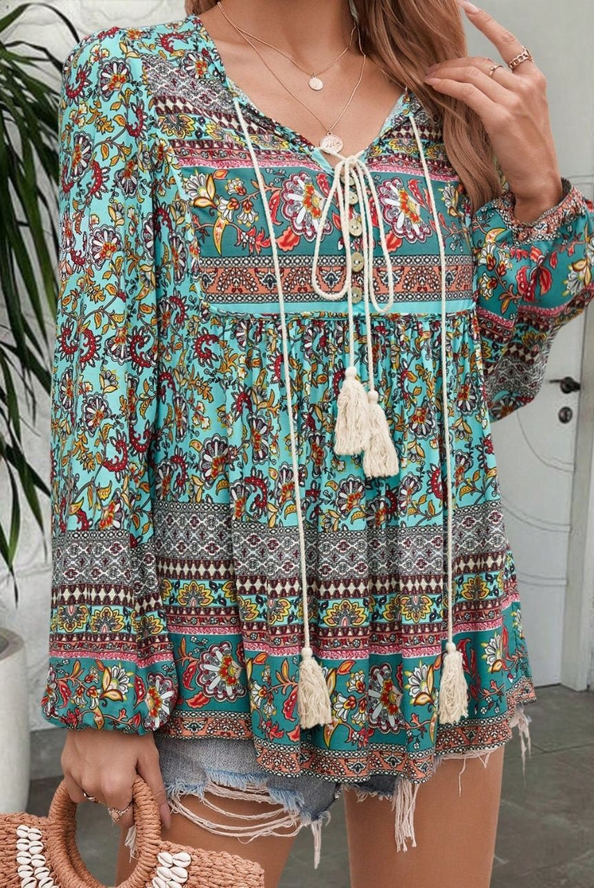 Woman in a vintage turquoise floral boho blouse with long peasant sleeves and tassel ties - The Jasmine Road Top Australia.
