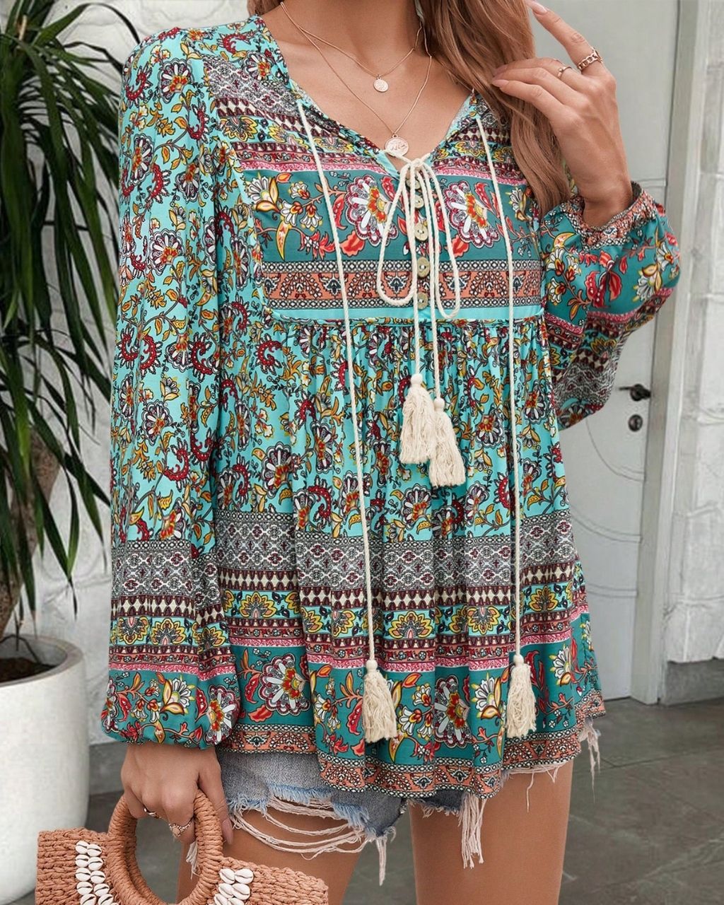 Woman in a vintage turquoise floral boho blouse with long peasant sleeves and tassel ties - The Jasmine Road Top Australia.
