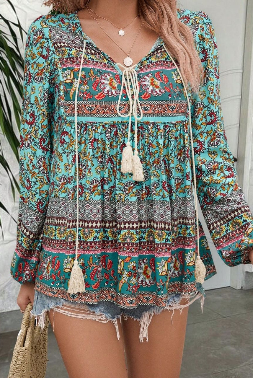 Woman in a vintage turquoise floral boho blouse with long peasant sleeves and tassel ties - The Jasmine Road Top Australia.