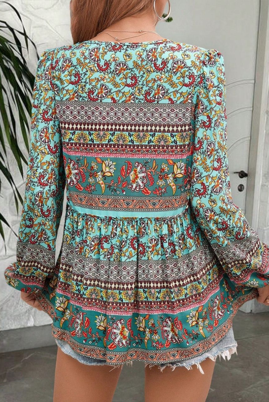 Woman in a vintage turquoise floral boho blouse with long peasant sleeves and tassel ties - The Jasmine Road Top Australia.