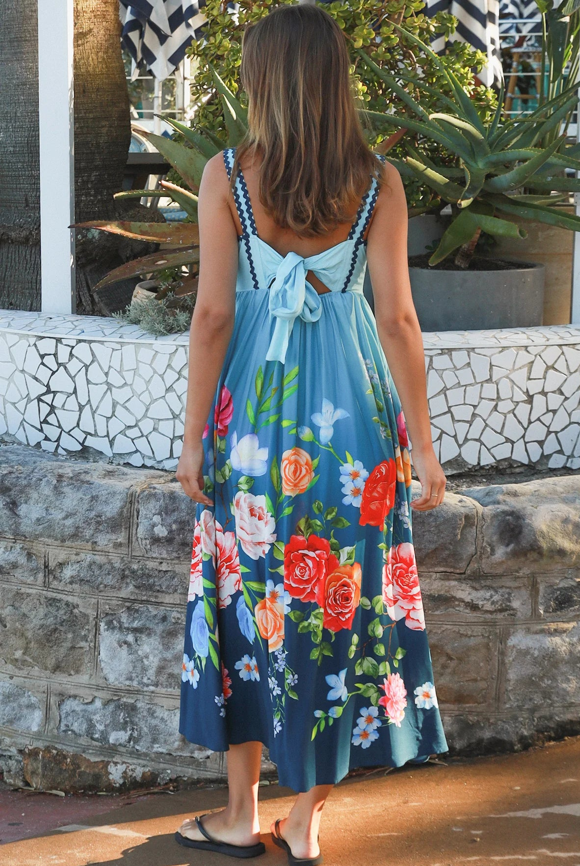 Woman wearing a teal floral boho maxi dress with tie-back detail, elasticated back and pockets – Australian bohemian fashion