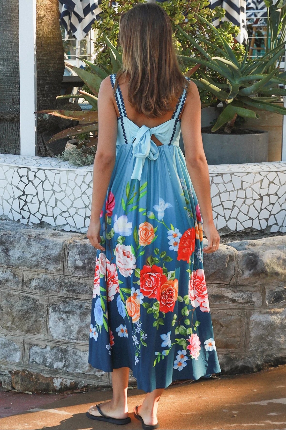Woman wearing a teal floral boho maxi dress with tie-back detail, elasticated back and pockets – Australian bohemian fashion