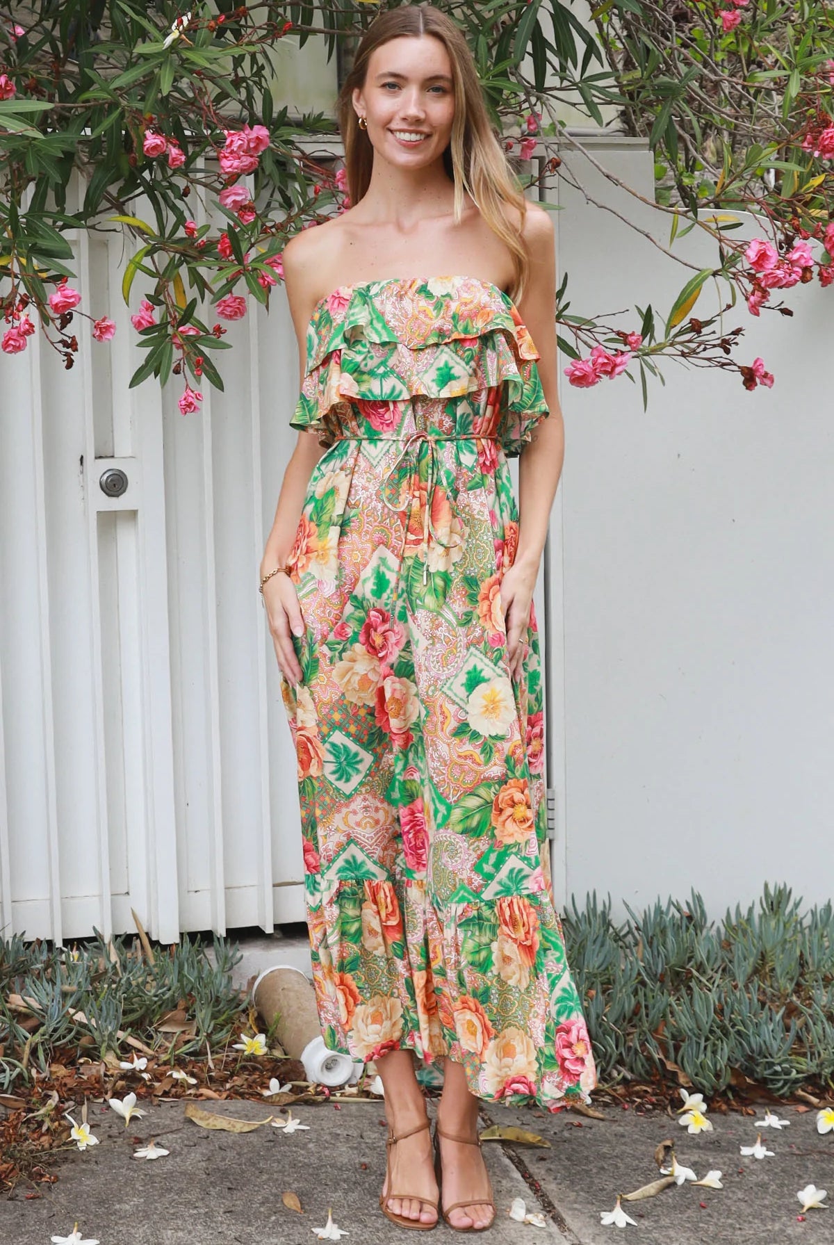 Model wearing a Dreamcatcher Raya strapless floral patchwork maxi dress in green and pink with ruffle bodice and tiered skirt