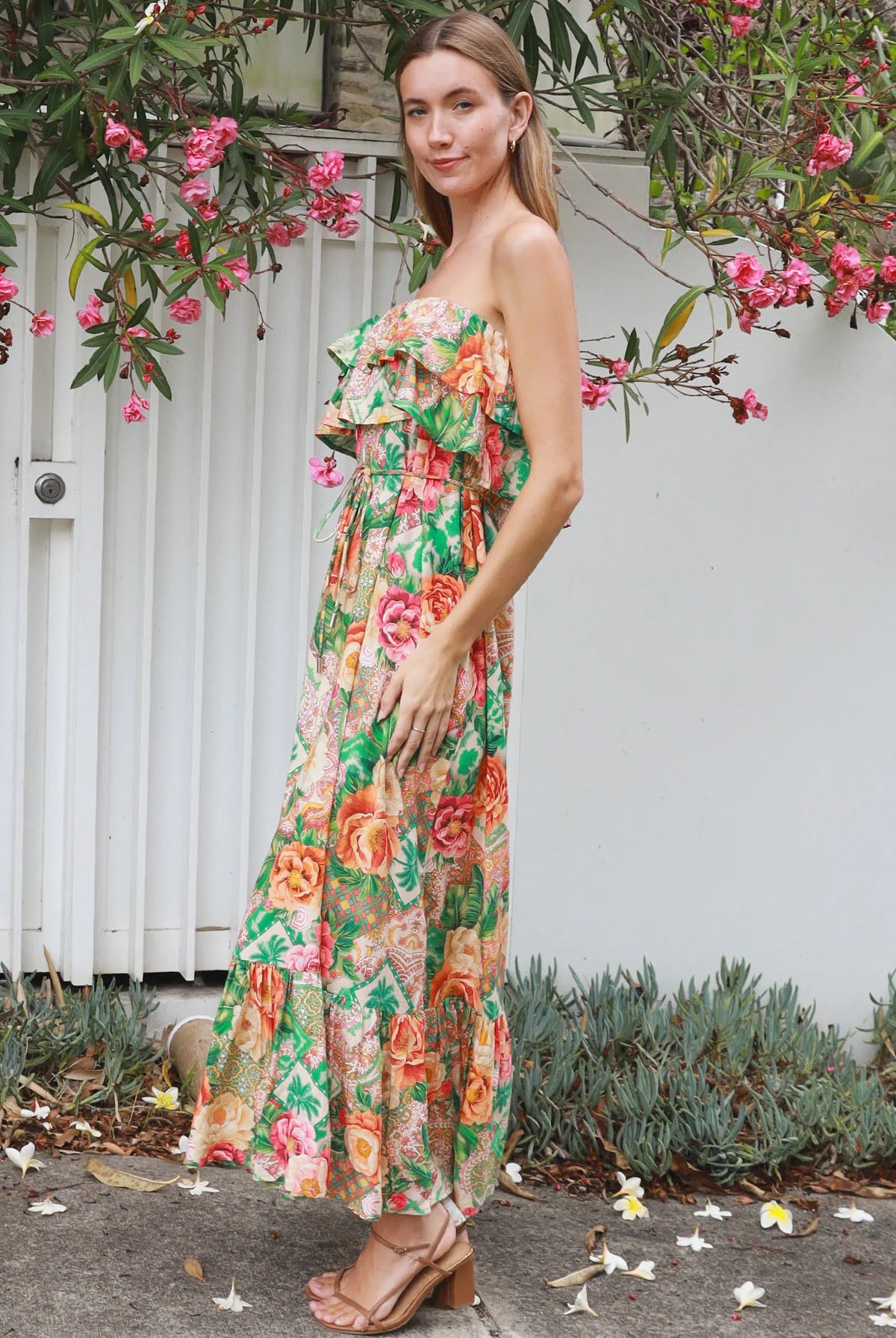 Model wearing a Dreamcatcher Raya strapless floral patchwork maxi dress in green and pink with ruffle bodice and tiered skirt