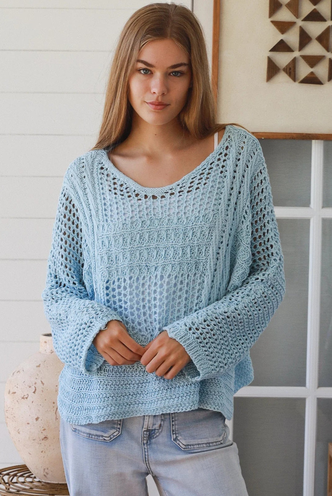 Woman wearing pastel blue crochet knit sweater styled with denim for a refined boho winter outfit Australia