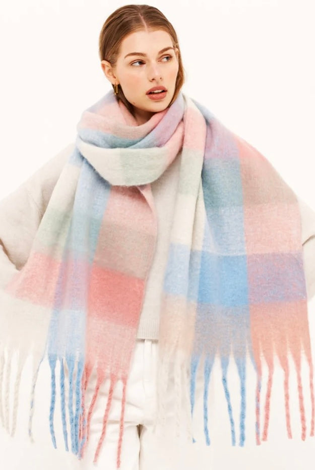 Woman in a pastel check boho winter scarf with blush, blue, and cream tones and long tassels - The Aurielle Scarf by Bohemian Love Runway