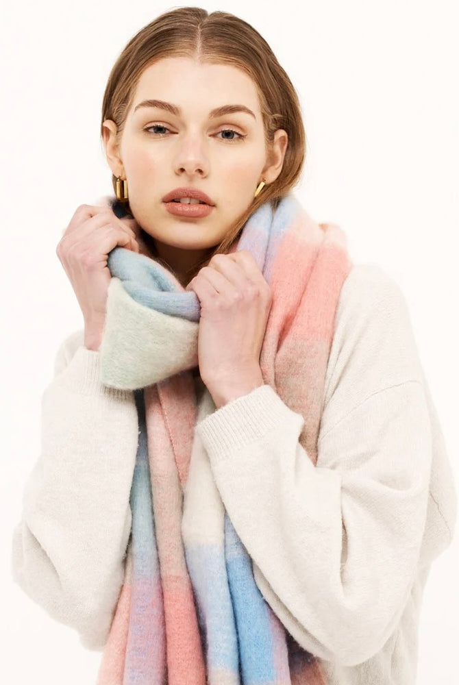 Woman in a pastel check boho winter scarf with blush, blue, and cream tones and long tassels - The Aurielle Scarf by Bohemian Love Runway