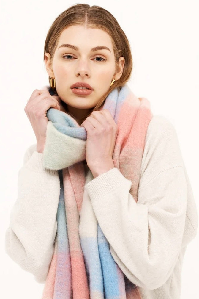 Woman in a pastel check boho winter scarf with blush, blue, and cream tones and long tassels - The Aurielle Scarf by Bohemian Love Runway