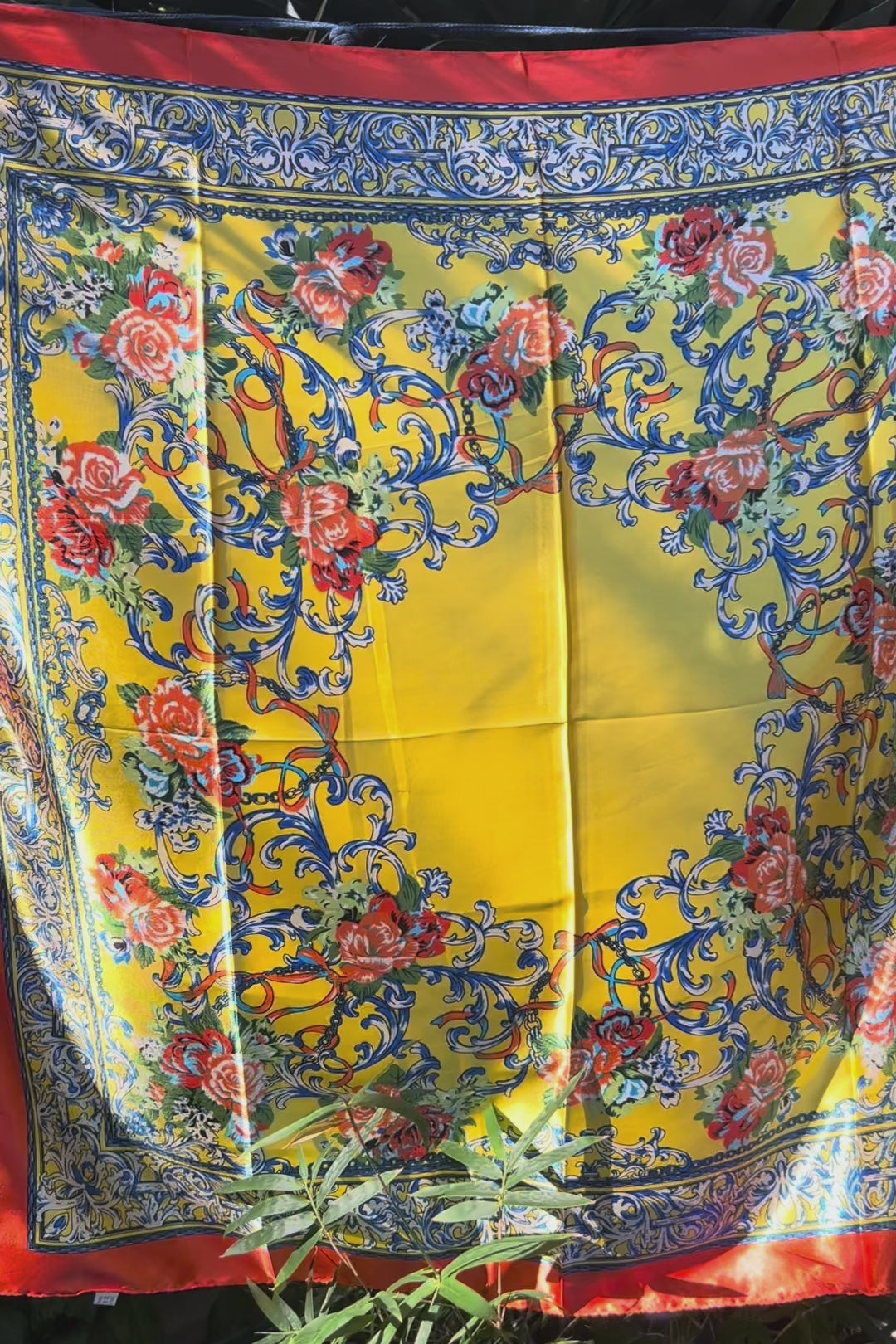 Yellow satin scarf with blue baroque scrolls and red floral print draped in sunlight - boho satin scarves Australia.
