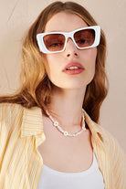 Women in square retro sunglasses with loose waves and yellow shirt—soft vintage boho look Australia.