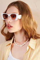 Women in square retro sunglasses with loose waves and yellow shirt—soft vintage boho look Australia.