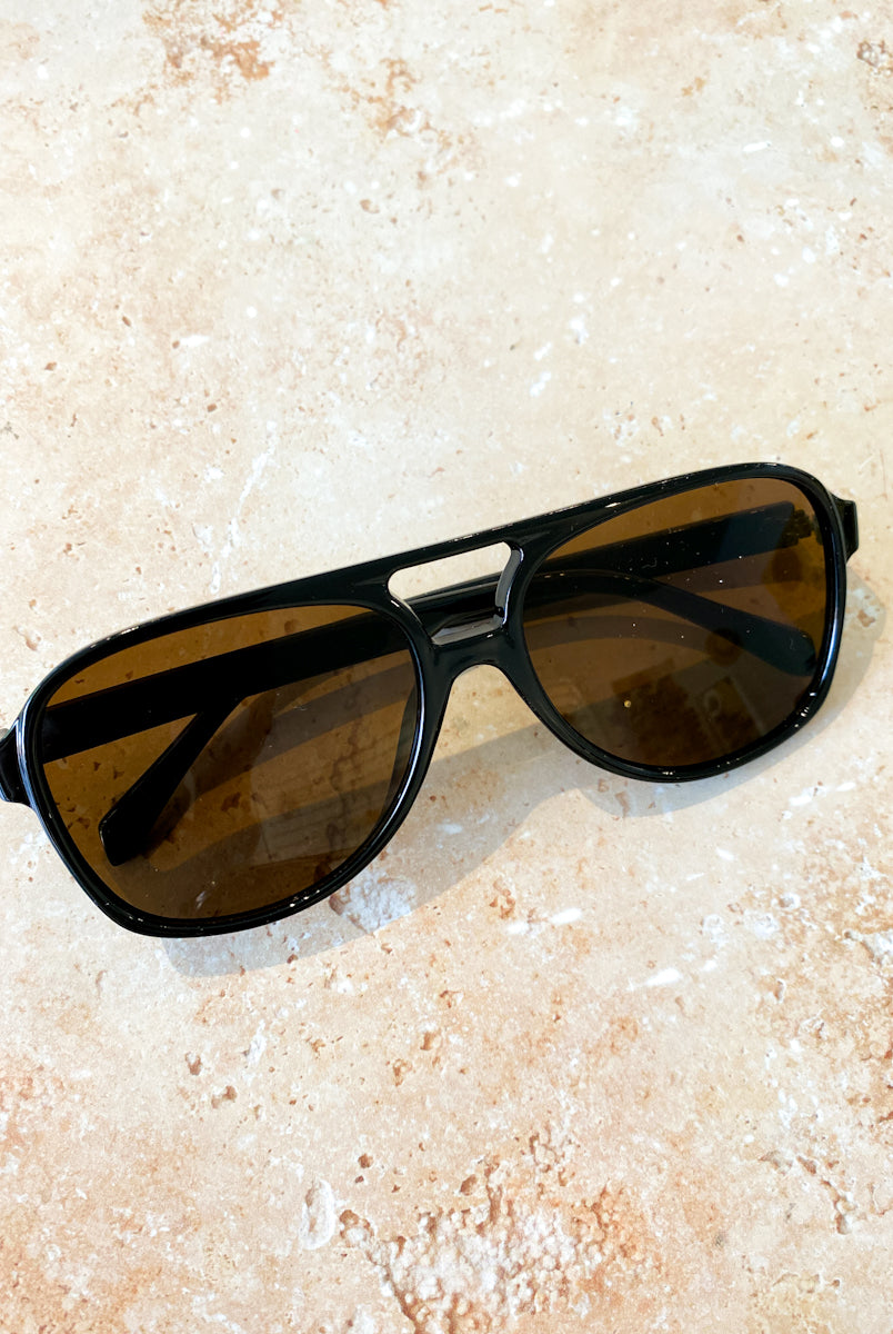 Quinn Aviator sunglasses with tinted lenses styled on a soft floral fabric - romantic flat lay boho fashion Australia.