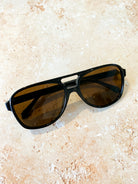 Quinn Aviator sunglasses with tinted lenses styled on a soft floral fabric - romantic flat lay boho fashion Australia.