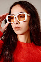 Woman in a white retro square sunglasses and red top with soft waves - bold boho fashion statement Australia.