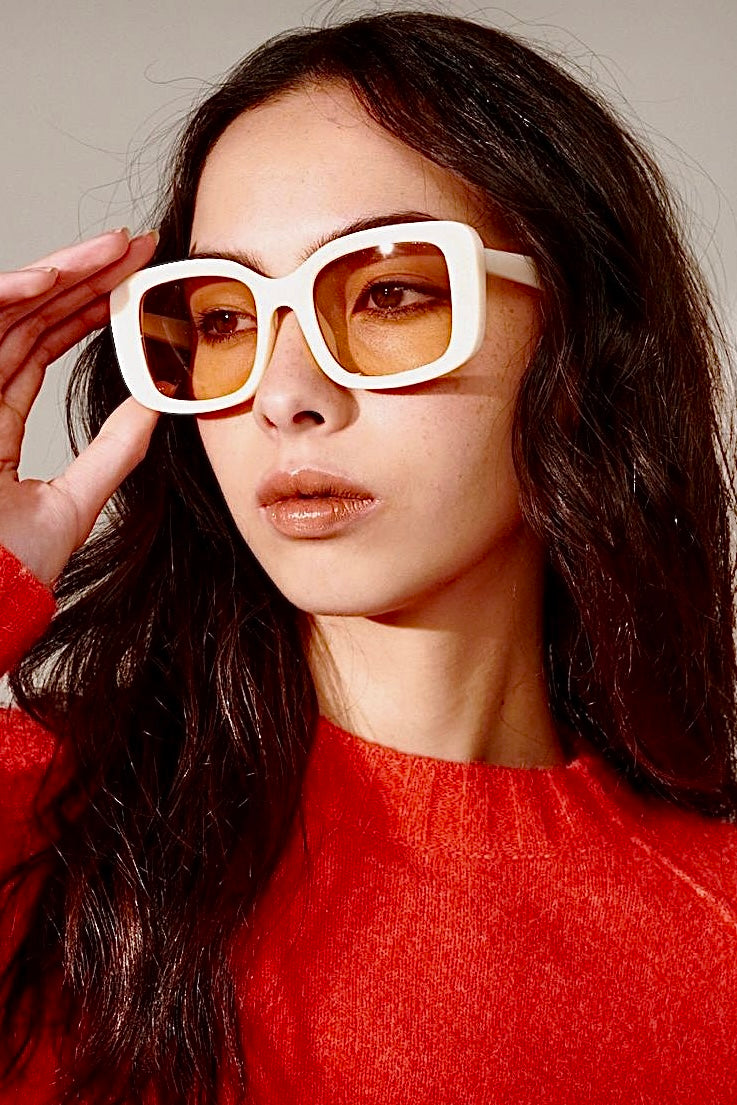 Woman in a white retro square sunglasses and red top with soft waves - bold boho fashion statement Australia.
