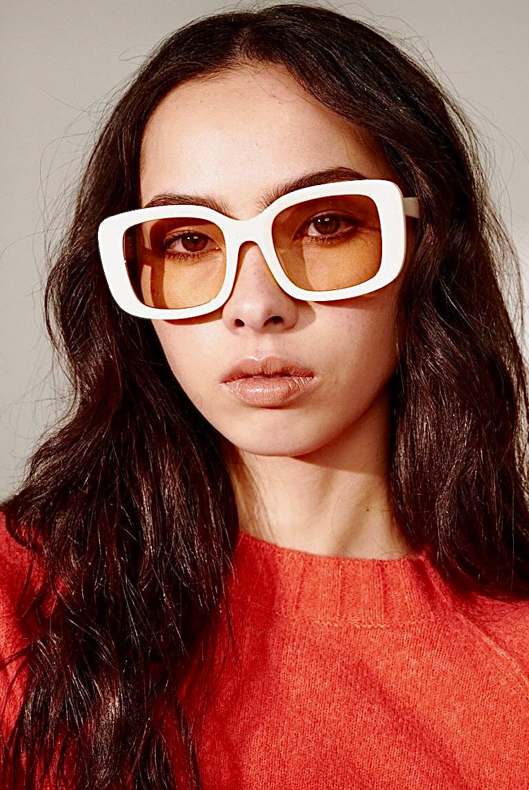 Woman in a white retro square sunglasses and red top with soft waves - bold boho fashion statement Australia.