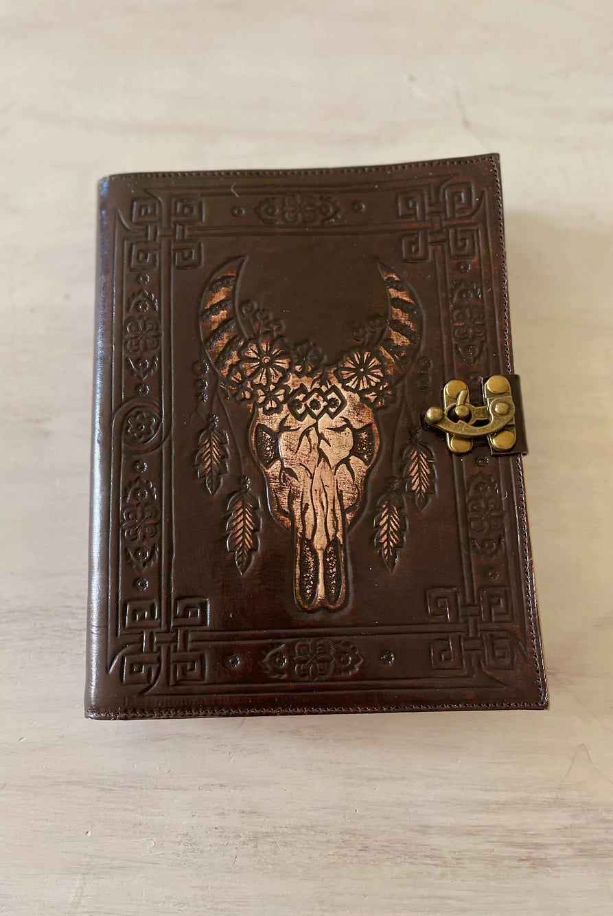 Dark leather journal with hand-tooled bull skull design on woven mat - Gypsy Toro boho journal from Bohemian Love Runway
