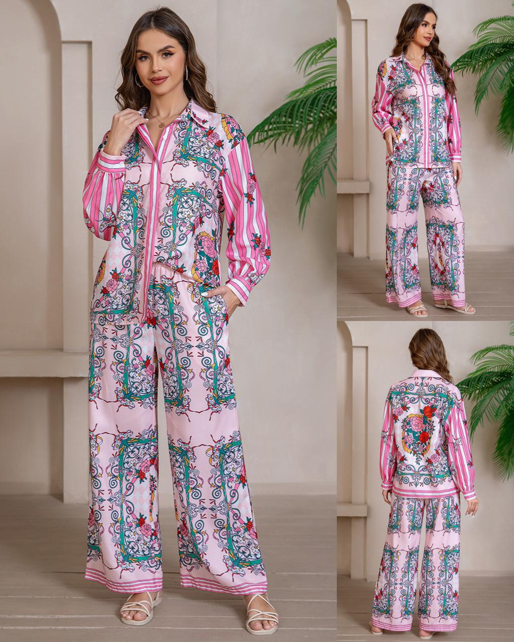 Model wearing a pink and white paisley-print boho co-ord set with wide-leg pants and an oversized button-down shirt, styled in a neutral indoor setting with soft lighting and leafy greenery.