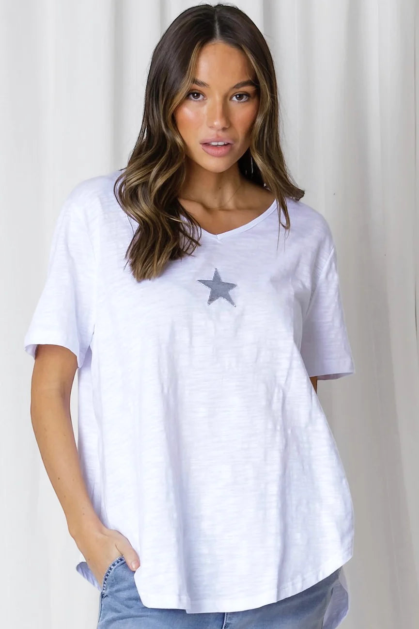 Every gal should rock a classic white tee! Elevate your look with the ELLA COTTON MINI STAR TEE - complete with a v-neckline, short sleeves, and a curved hemline that's longer in the back with a sequin silver star. 