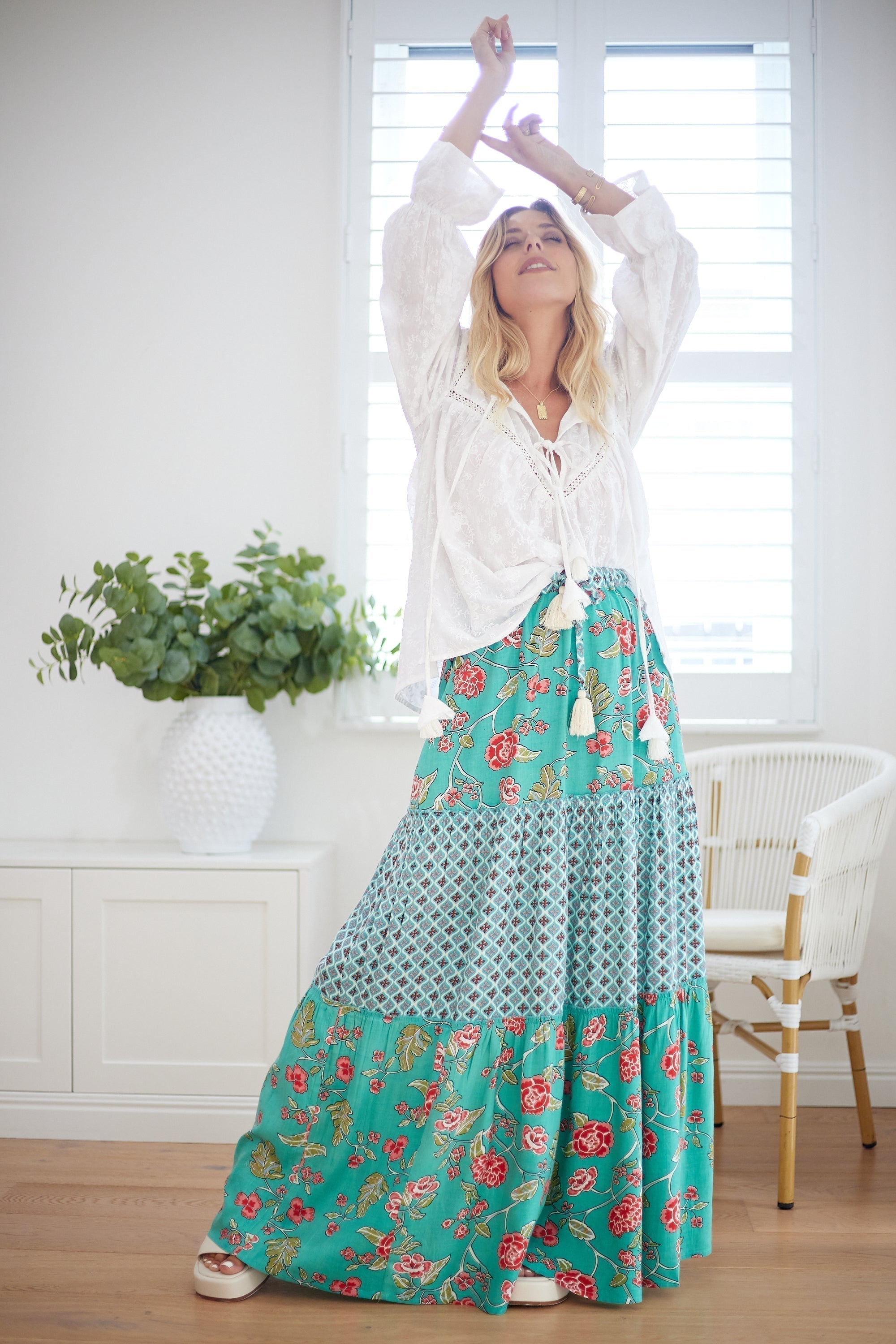 model wearing a boho maxi skirt with a tiered hem and earthy floral print - a silhouette that glides with effortless elegance.