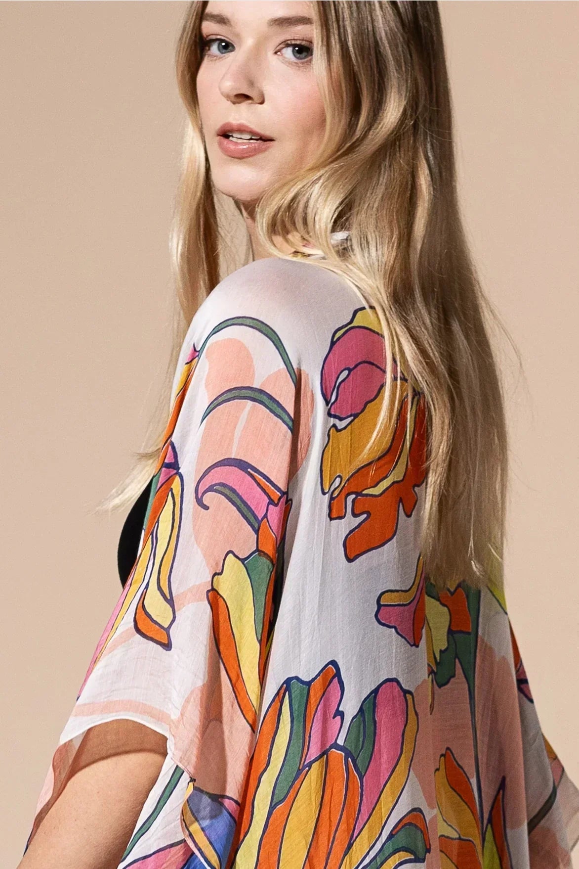 Woman in a pastel floral boho kimono looking over shoulder - Australian bohemian fashion style.