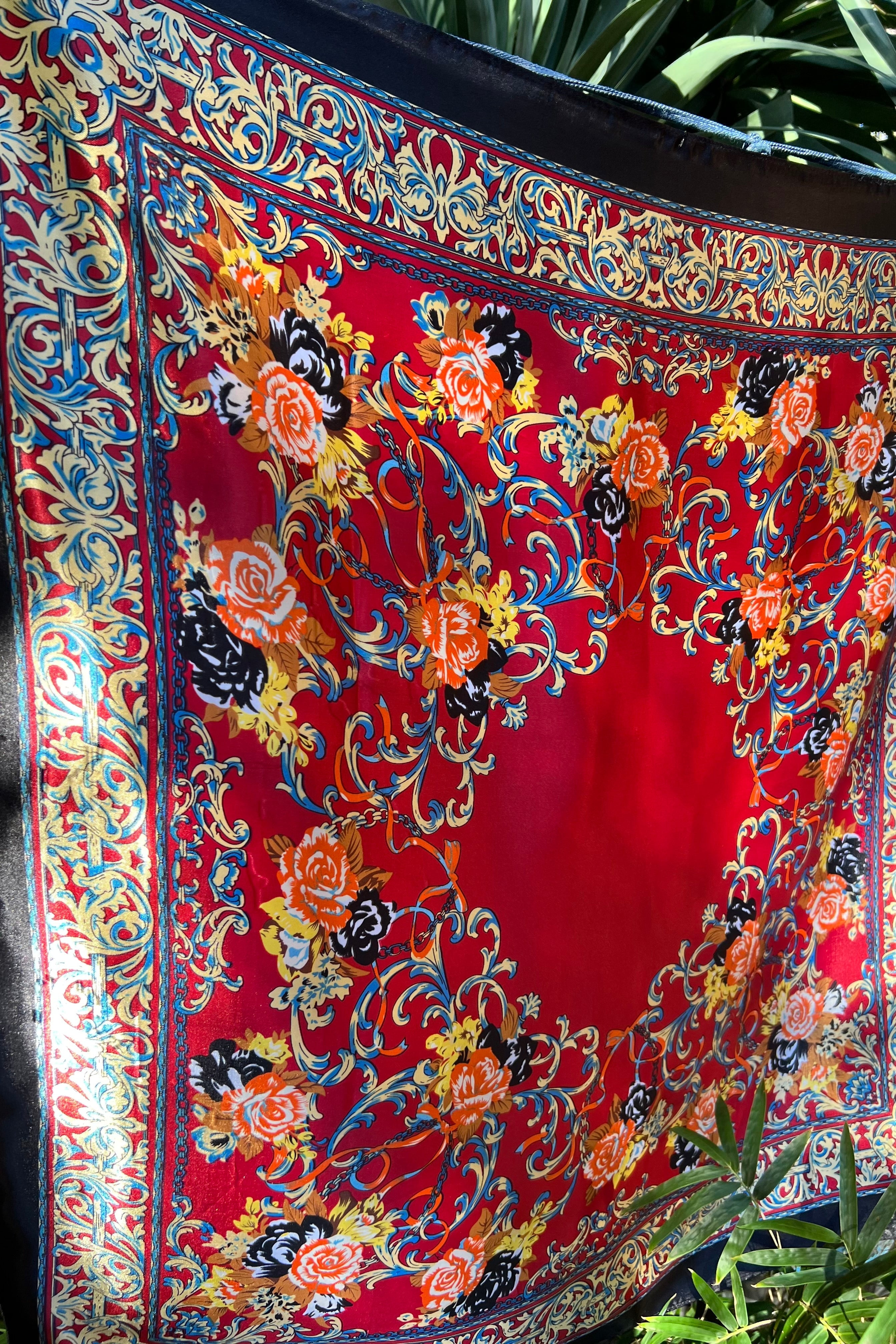 Red and navy resort-style square scarf with vibrant floral border and ornate baroque detailing — ideal for tropical escapes and luxury summer styling.