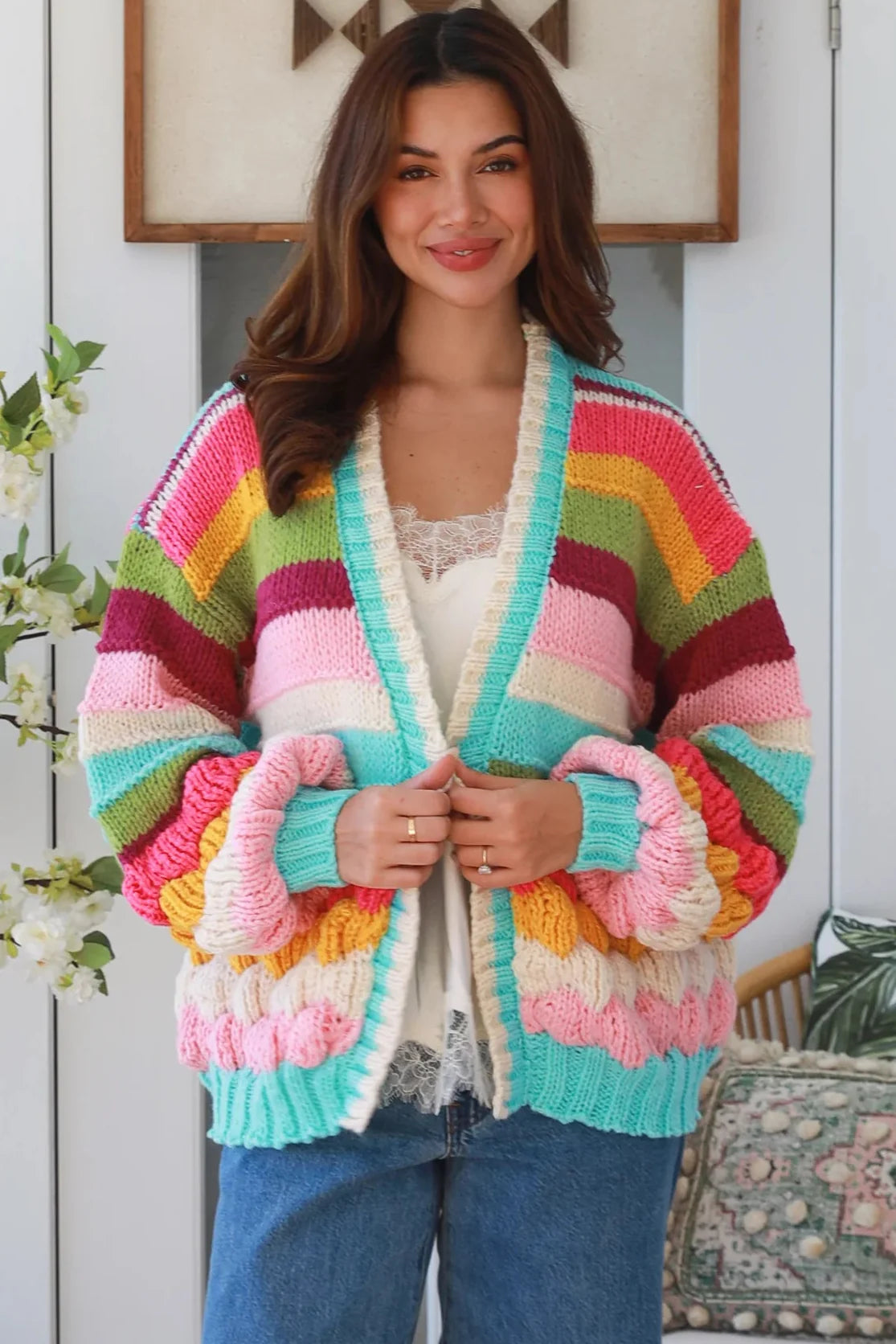 Woman wearing colourful striped boho cardigan with lace cami and jeans – boho clothing Australia.