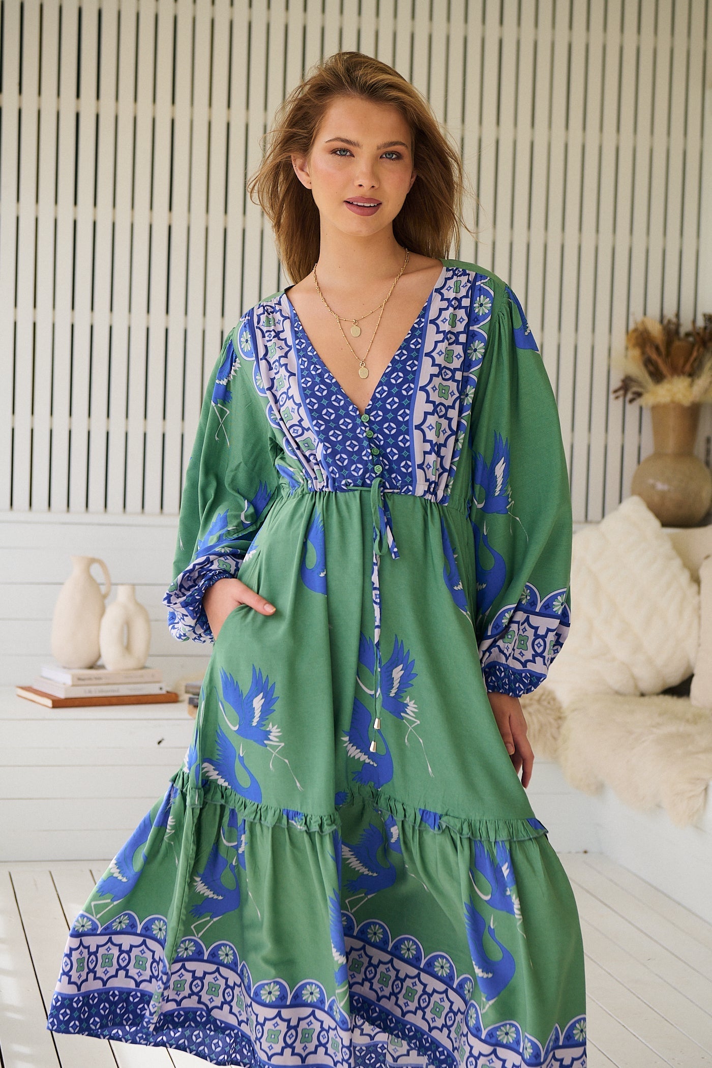Woman in a green and blue JAASE tiered midi dress standing on a breezy porch - Bohemian Love Runway 